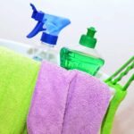 a cleaning bucket with colorful towels and cleaning products