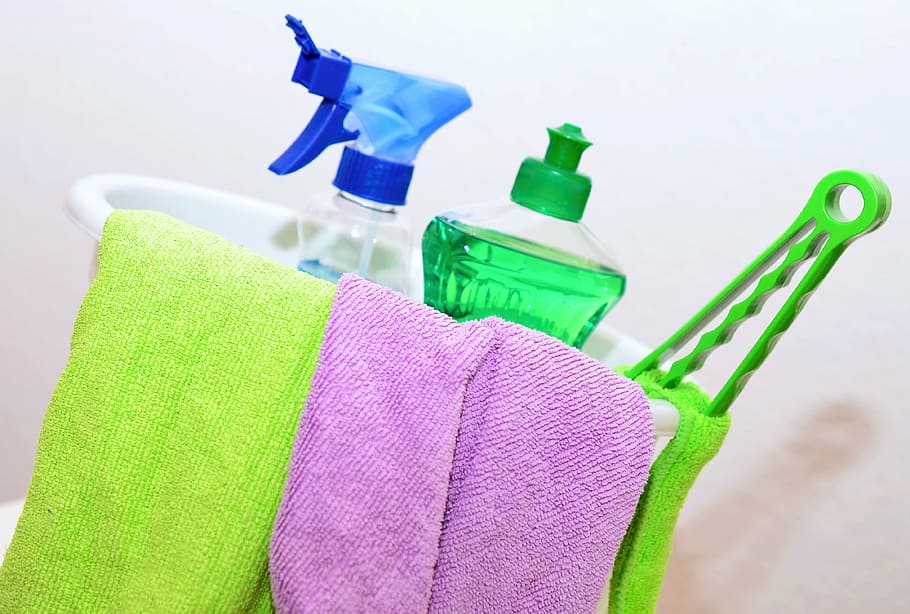 a cleaning bucket with colorful towels and cleaning products