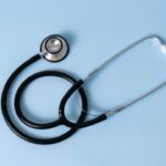 A stethoscope on a blue background, symbolizing medical examination.